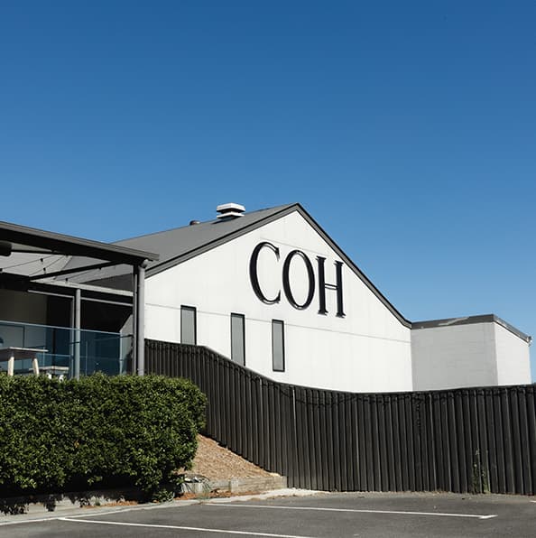 Exterior of the City on a Hill Church building with COH signage under a clear blue sky