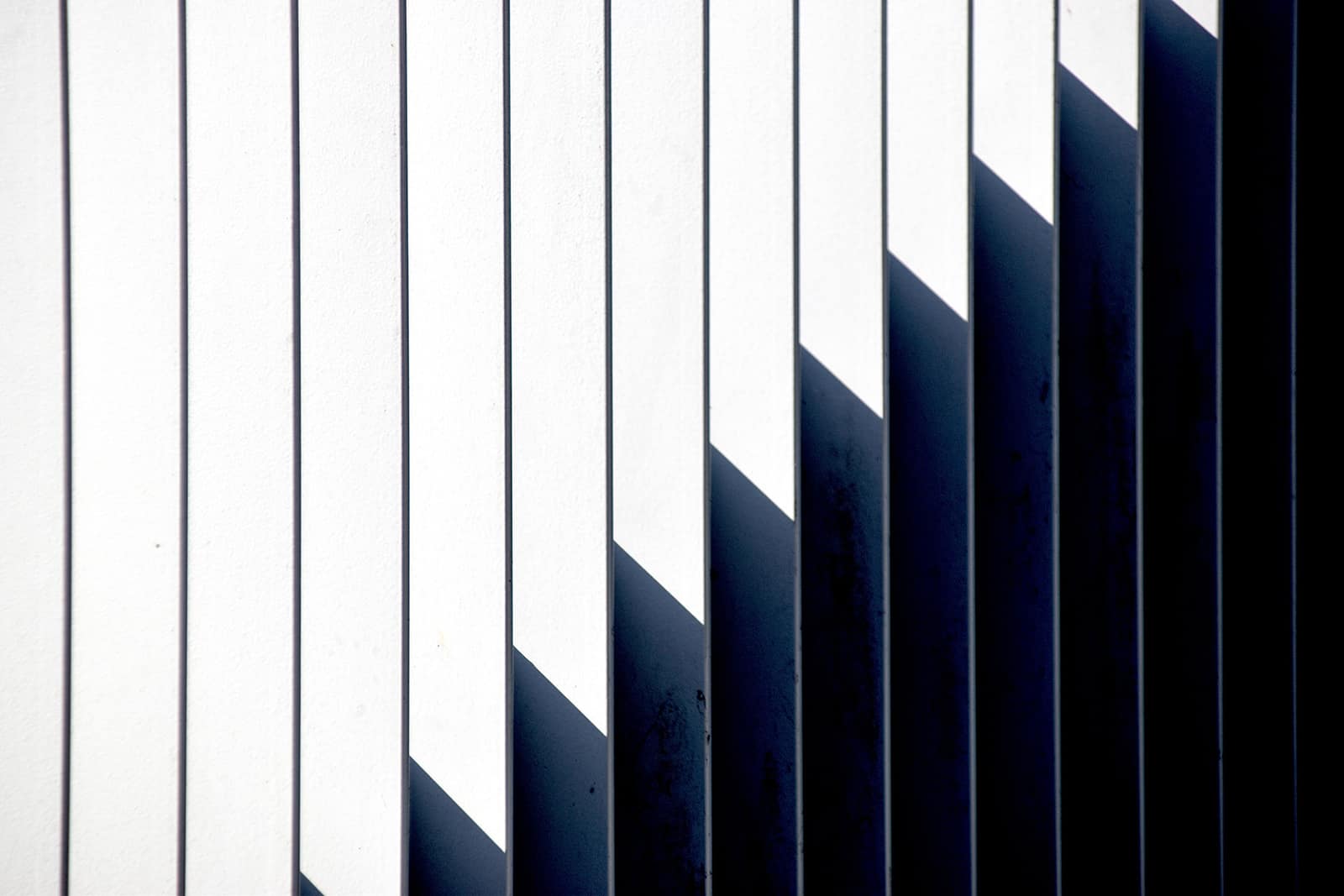 Abstract shadow lines on a white wall illustrating City on a Hill Church’s mission to reach people